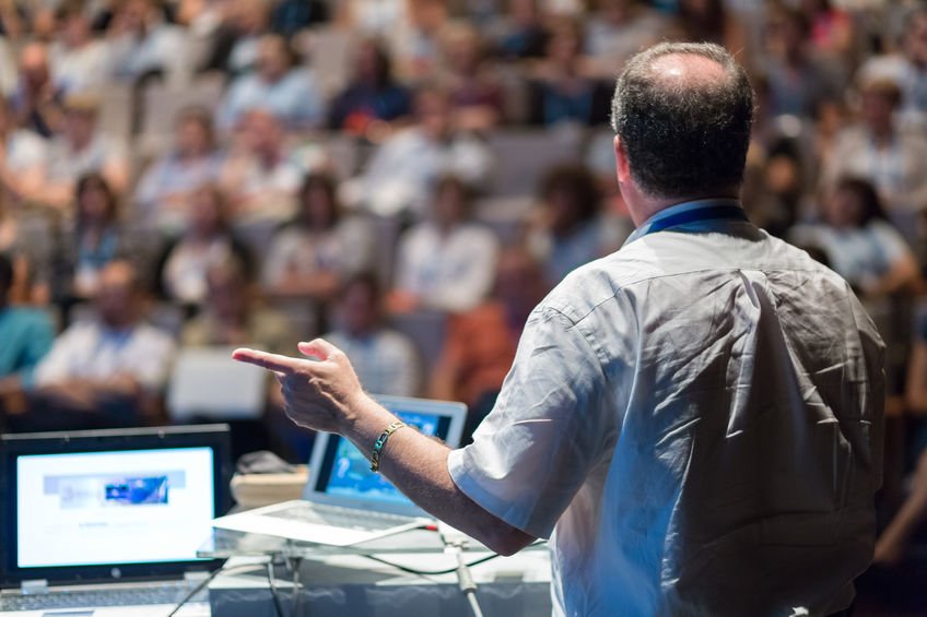 Public speaker giving talk at Business Event.